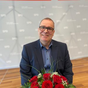 Thorsten Krüger mit einem Strauß roter Rosen
